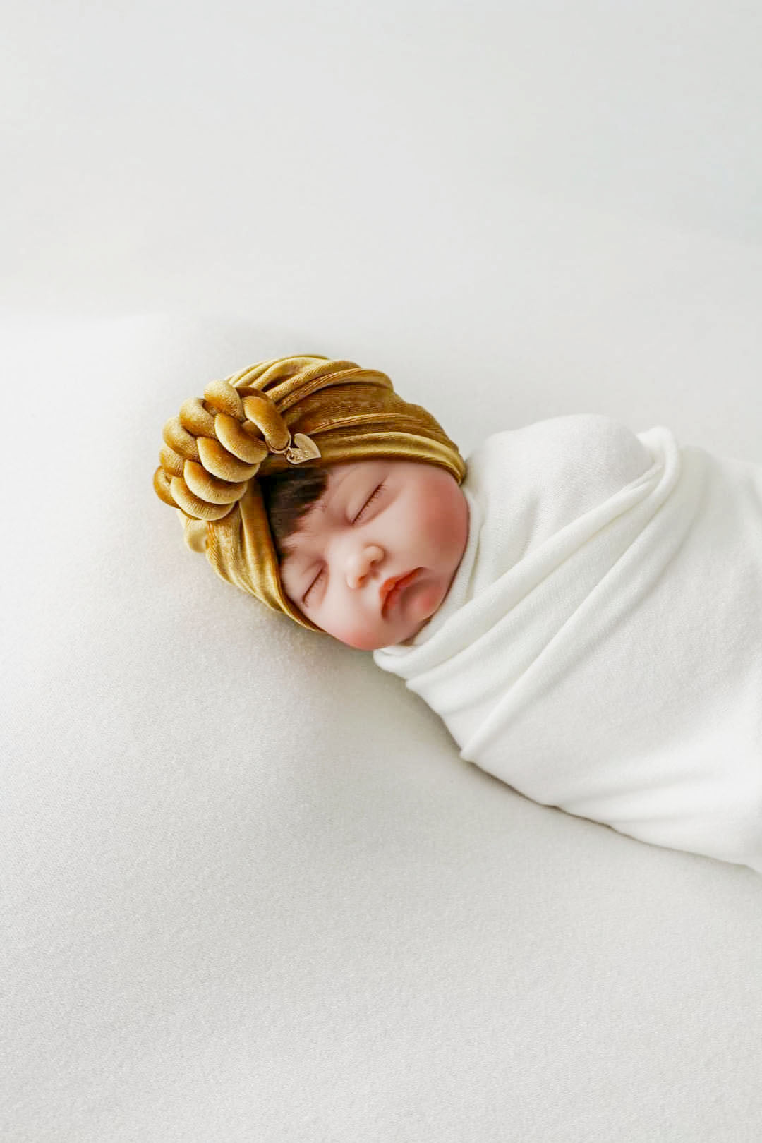 Baby girl velvet turban knot in gold color close-up view