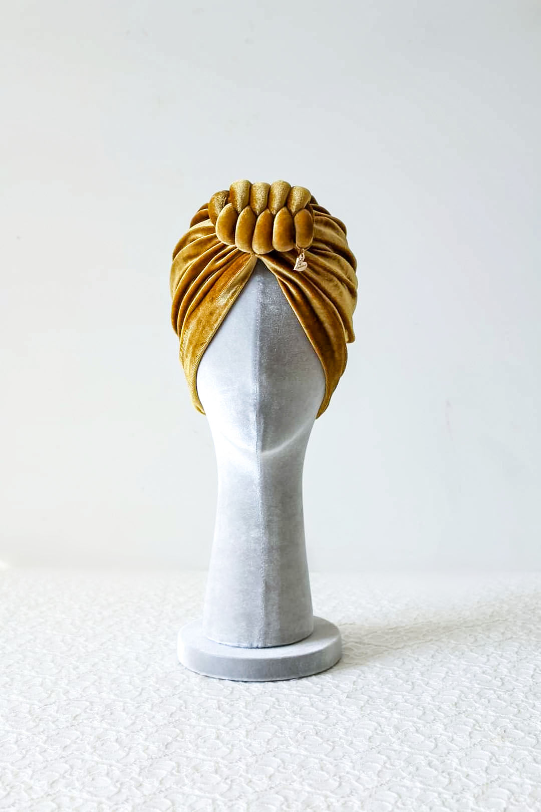 Velvet turban knot in gold color frontview